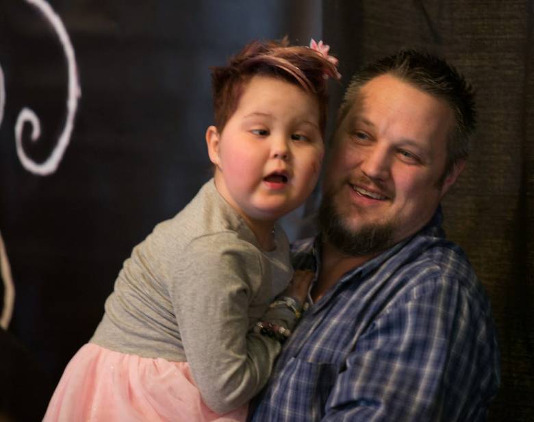 Lily LaRue Anderson rests on her father Brian's shoulder after a fundraiser held in Garfield for four North Jersey sick children earlier this year.